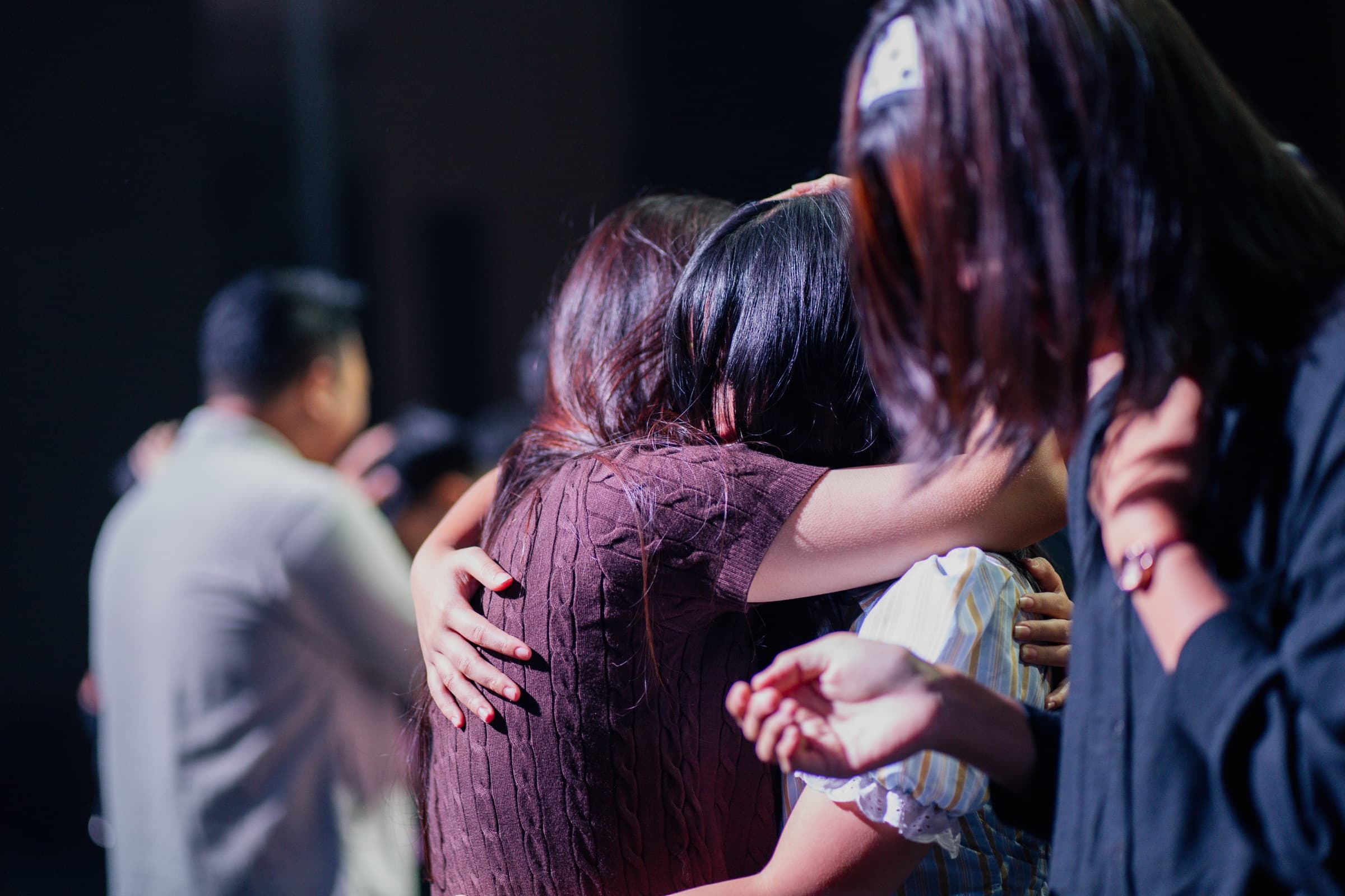 People embracing during worship at Sukawarna Legacy